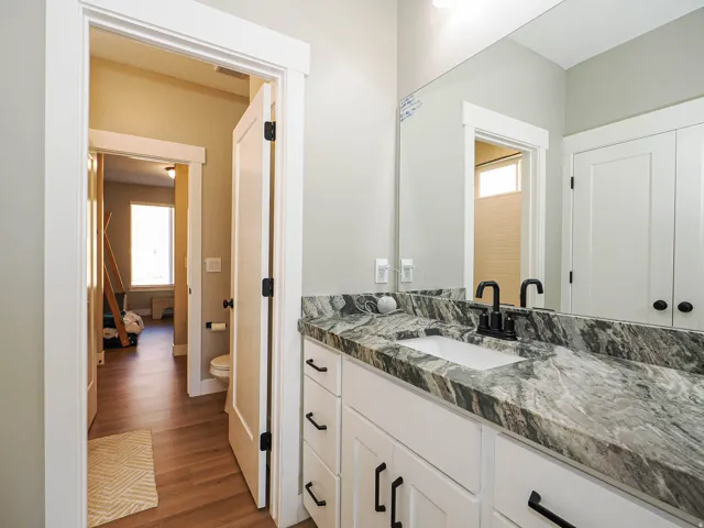 Bathroom vanity with a rectangular undermount sink, a gray and white patterned countertop, and a matte black faucet