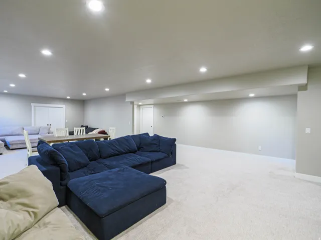 Expansive open-concept room featuring light-toned carpeting and recessed ceiling lighting