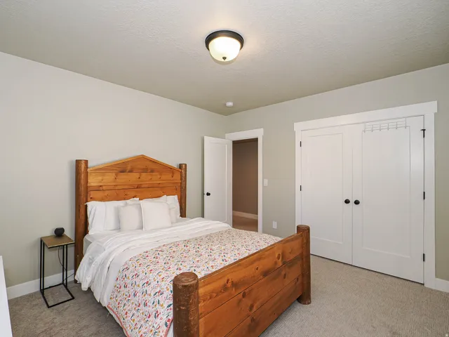 Carpeted bedroom featuring neutral wall tones and a ceiling-mounted light fixture