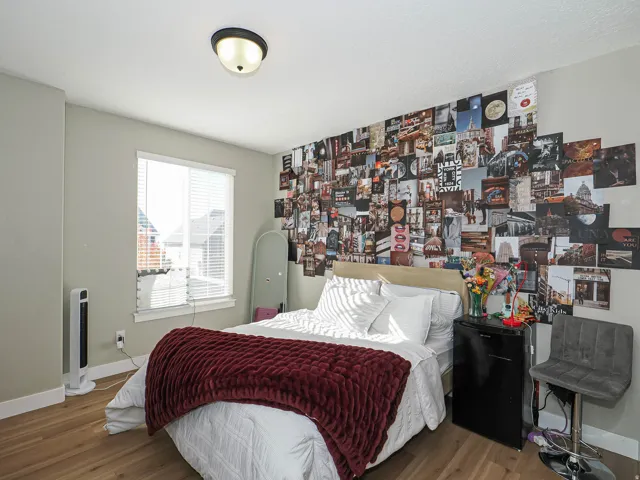 Light-filled room featuring wood-finish flooring, a window with blinds, and a flush-mount ceiling light