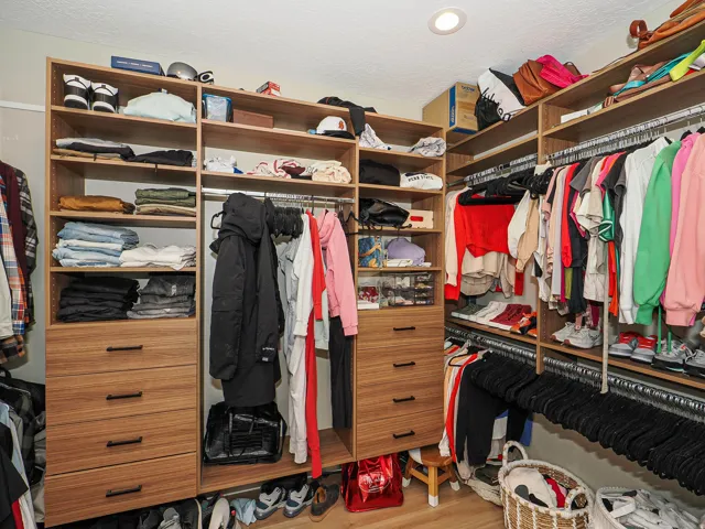 Custom closet system featuring wood-finish shelving, integrated drawers, and ample hanging space