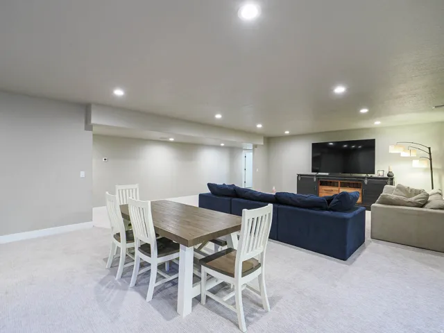Expansive lower-level space featuring recessed lighting, light-toned carpeting, and a built-in media console