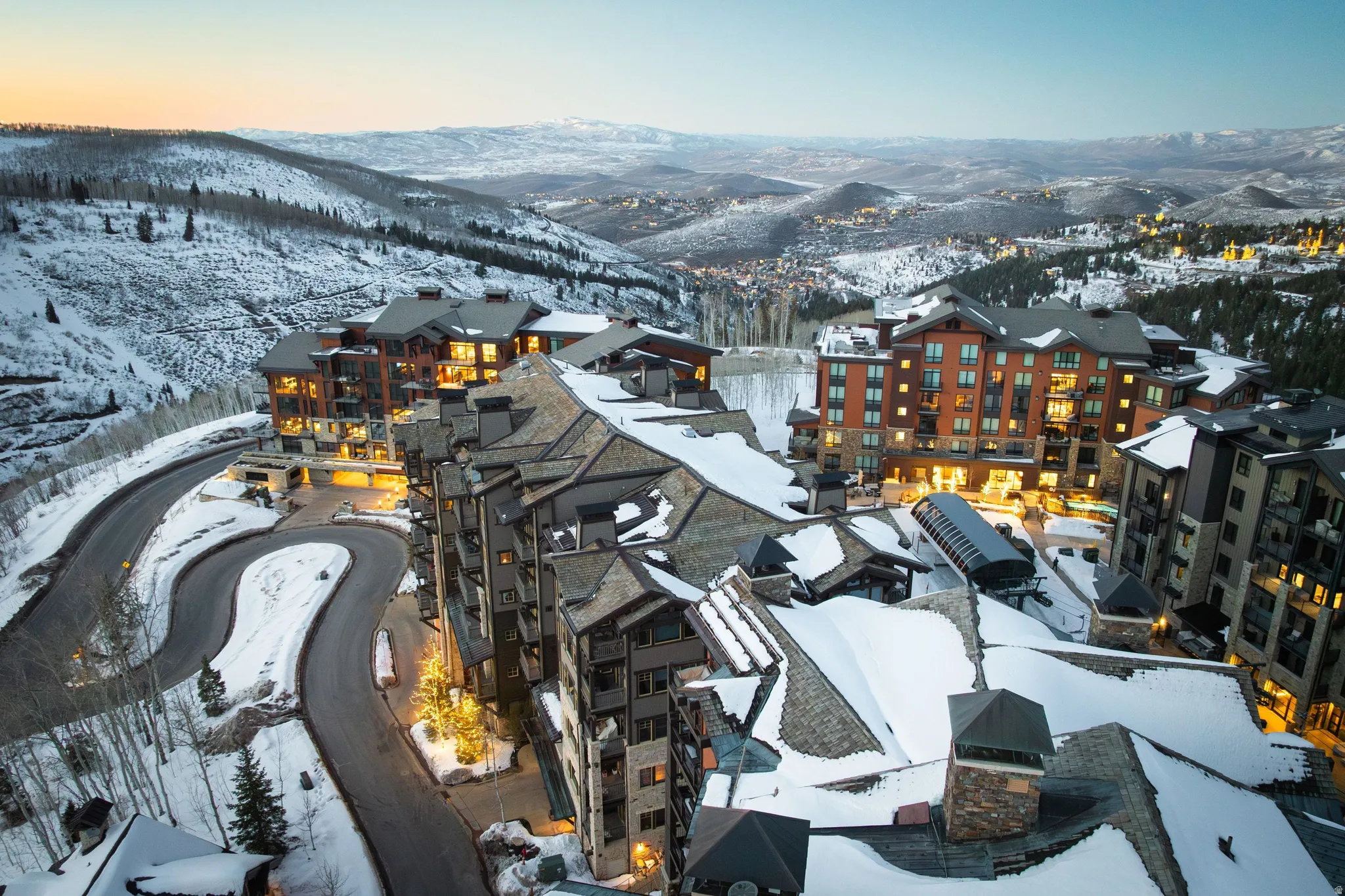 Alpine resort community featuring multiple buildings with stone and wood panel exteriors, pitched roofs, and balconies