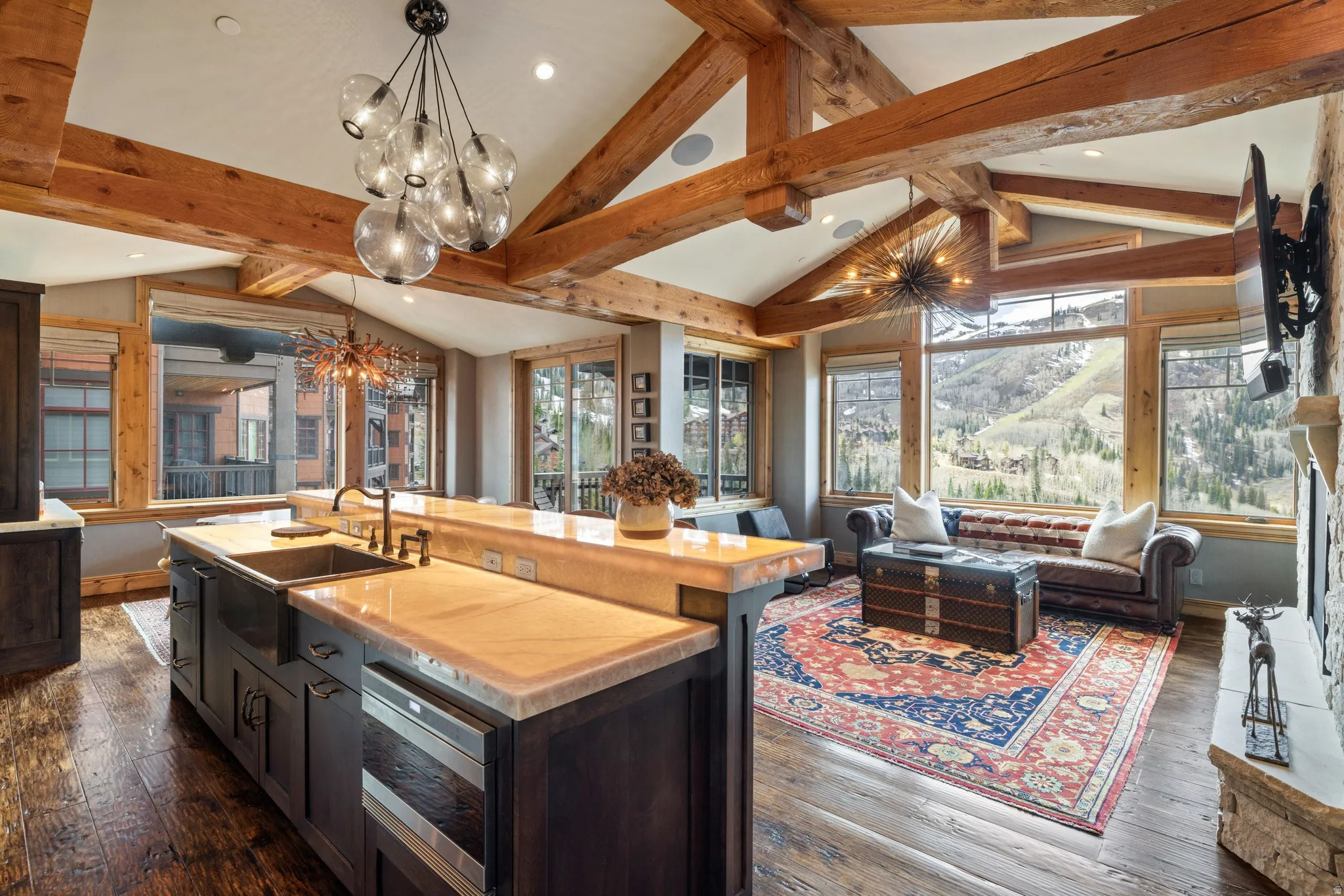 Vaulted ceilings with exposed wood beams define this open-concept room