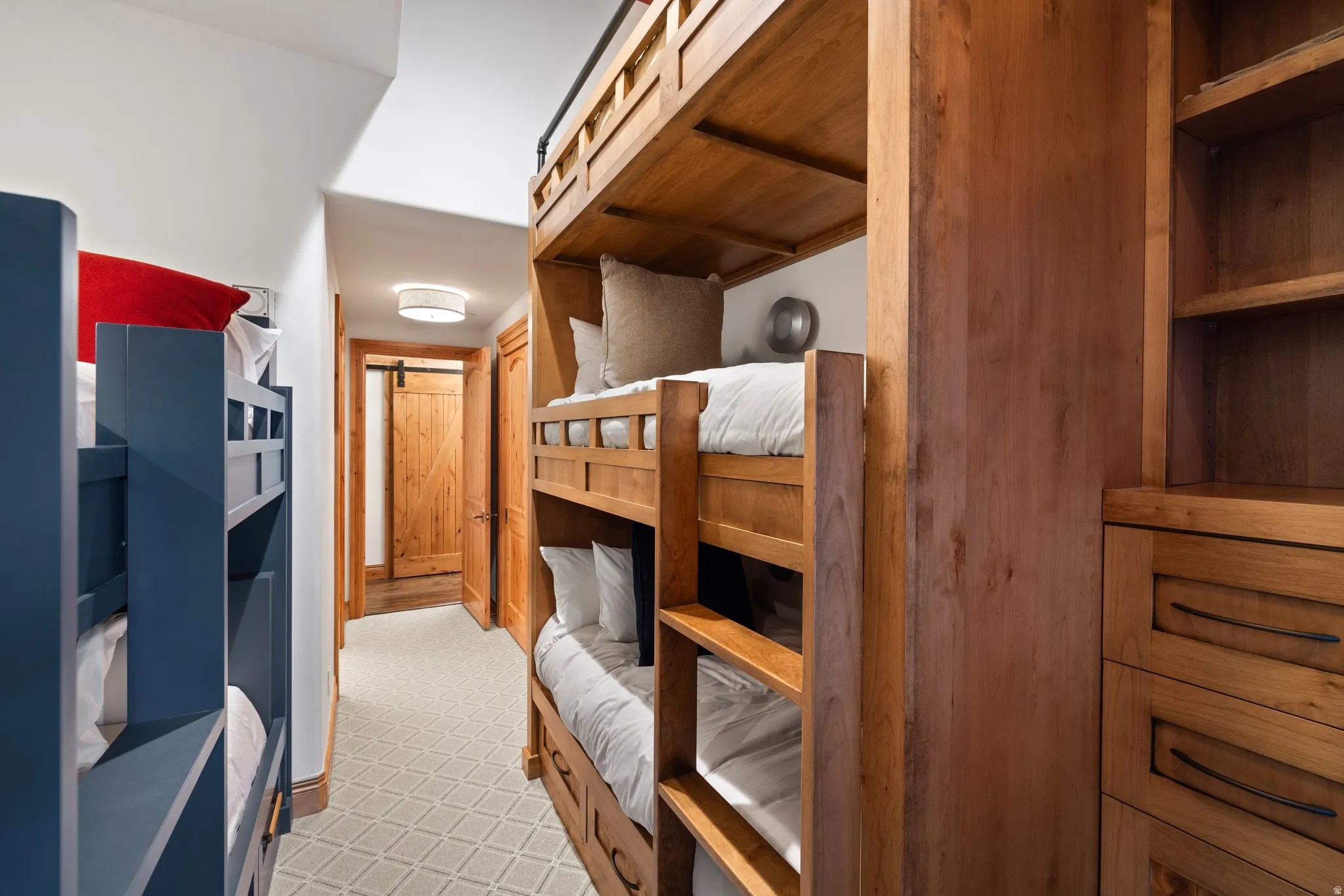 Dedicated bunk room featuring built-in wooden bunk beds, integrated shelving, and drawer storage