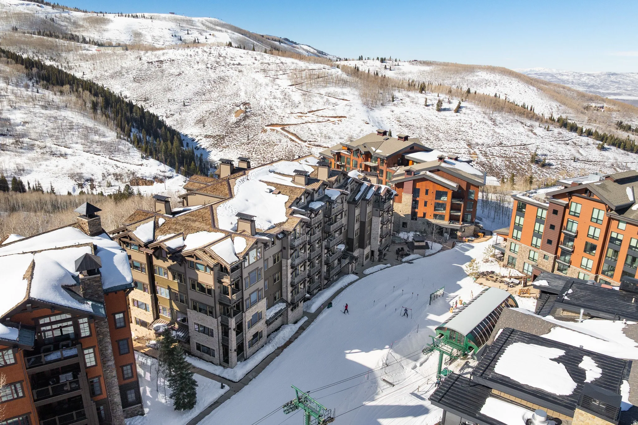 Ski-in/ski-out residences featuring multiple buildings with stone and wood siding, pitched roofs, and balconies