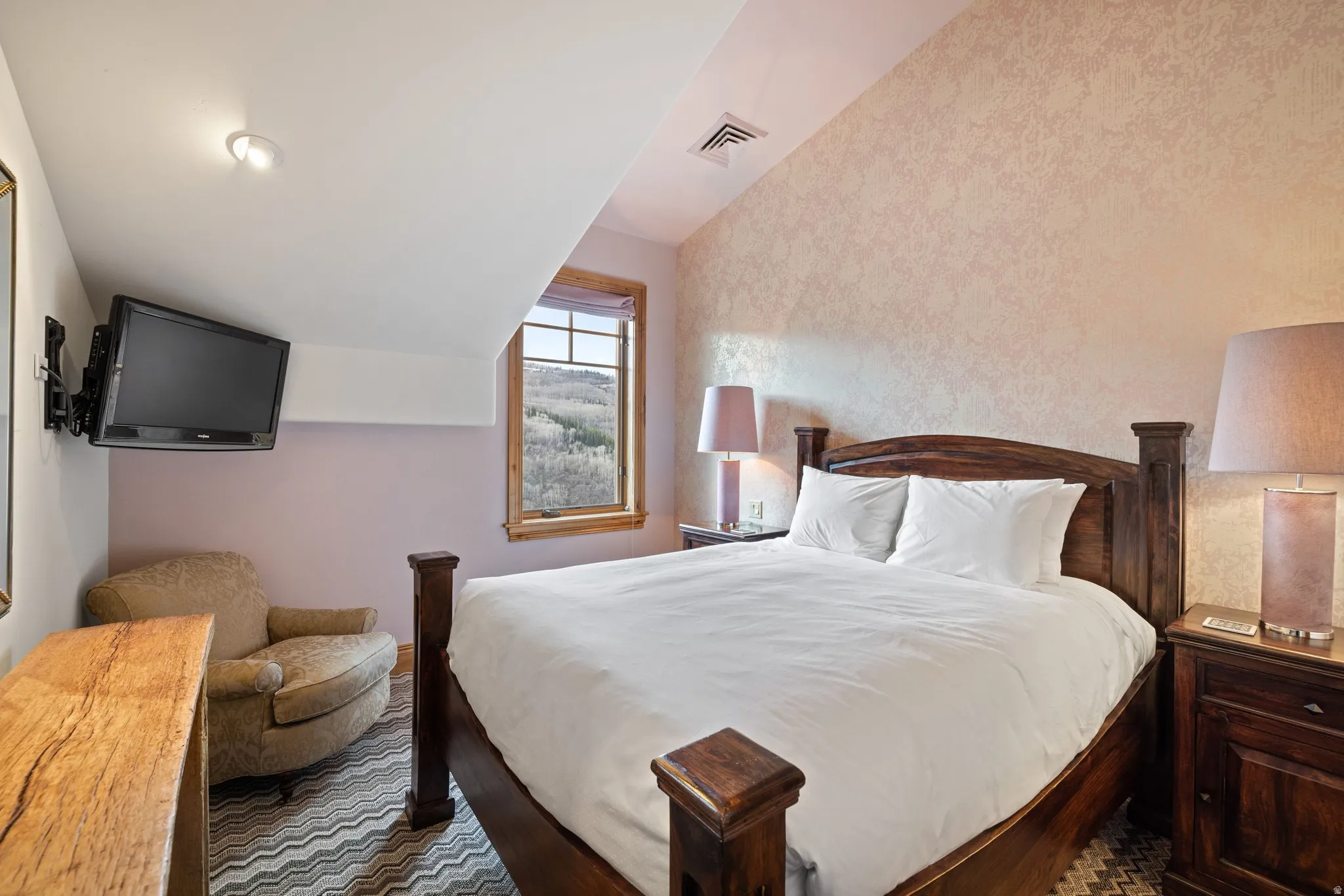 Room featuring an angled ceiling, window with wood trim, recessed lighting, and patterned carpet