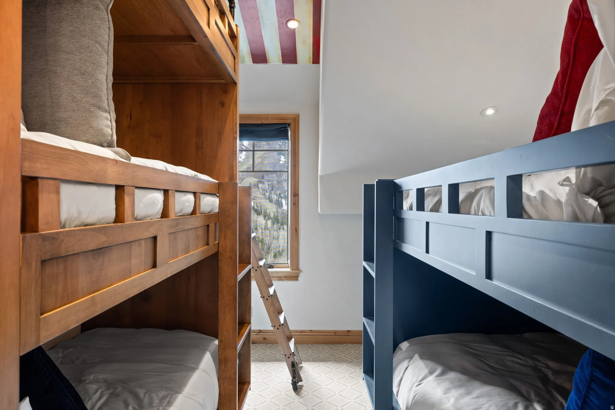 Bunk room featuring two distinct bunk bed styles, recessed lighting, patterned carpet flooring, and a window with wood trim