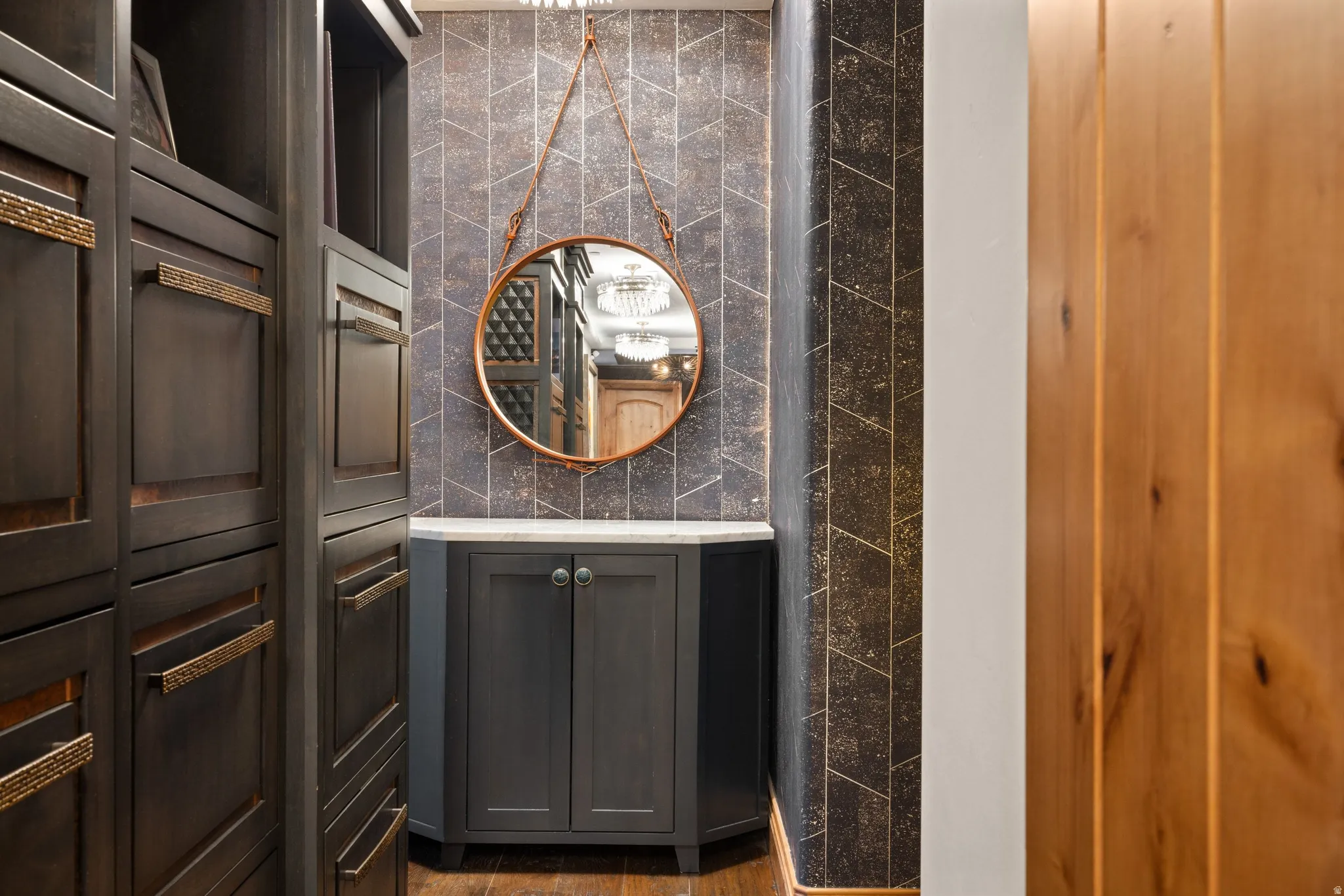 Custom built-in cabinetry featuring dark wood-finish paneling and brass hardware