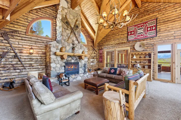 Spacious living area featuring log walls and a vaulted log ceiling