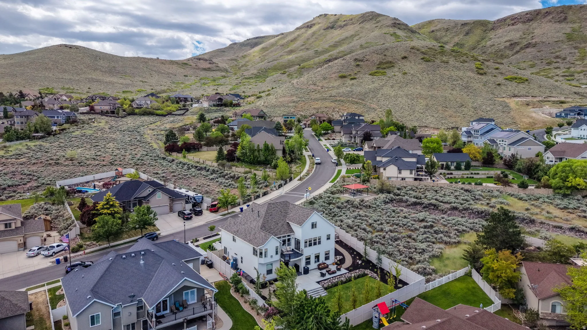 Suburban neighborhood set against a natural mountain backdrop, featuring various architectural styles and mature landscaping