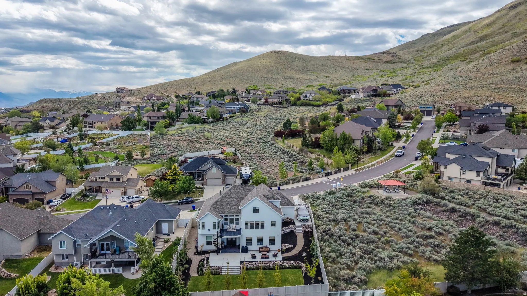 Expansive property featuring a white two-story residence with a multi-level deck and fenced backyard