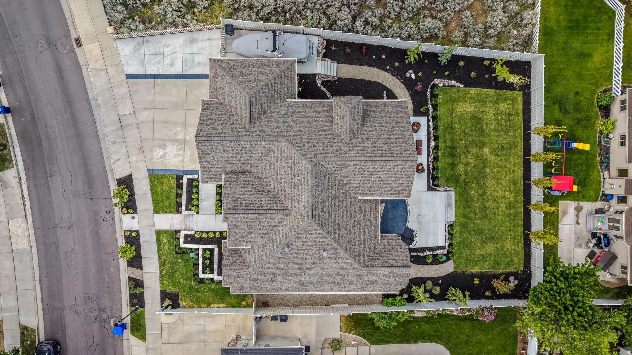 Expansive property featuring a multi-gabled roofline, concrete driveway, and a large manicured lawn