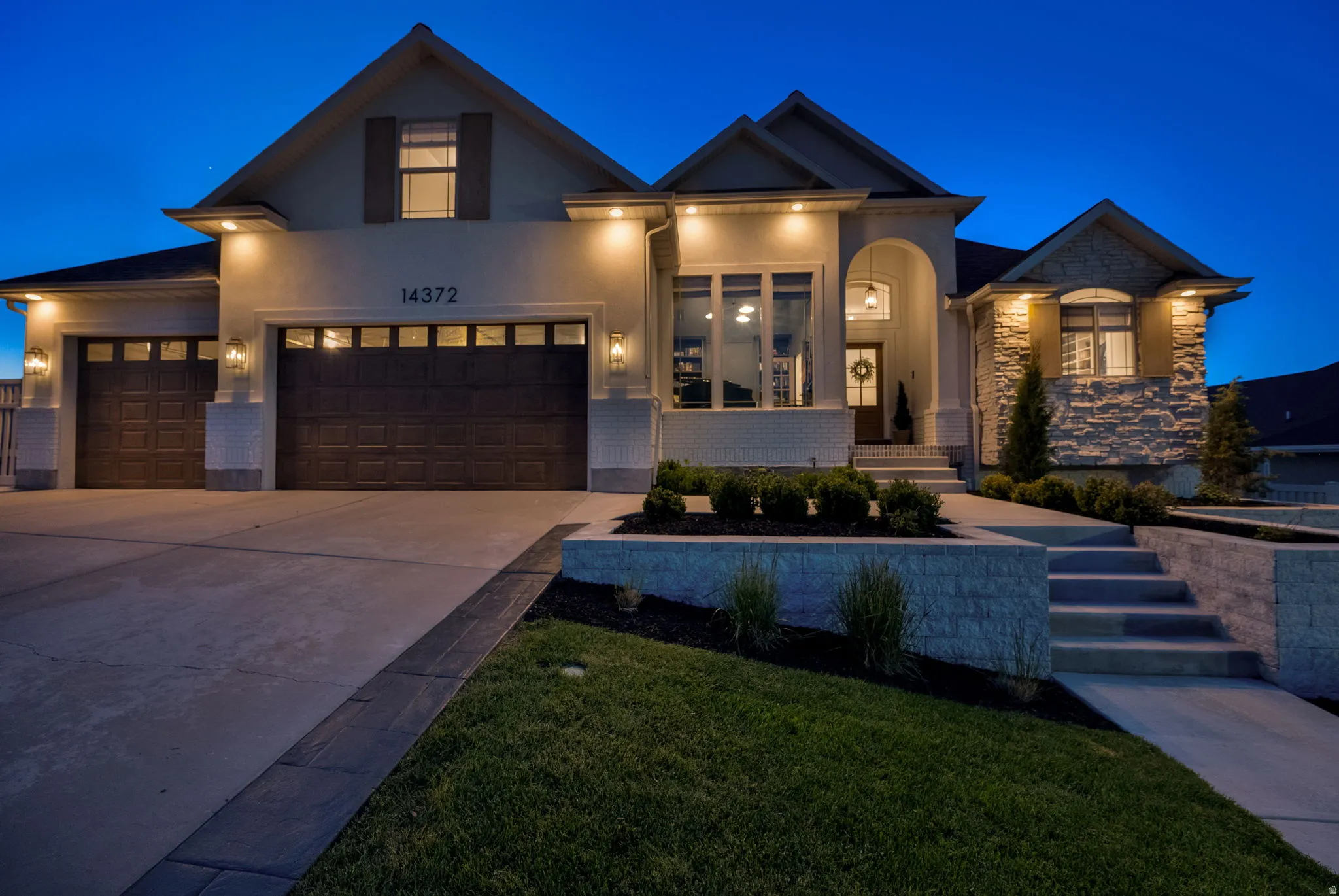 Contemporary residence featuring a light-colored stucco and stone facade