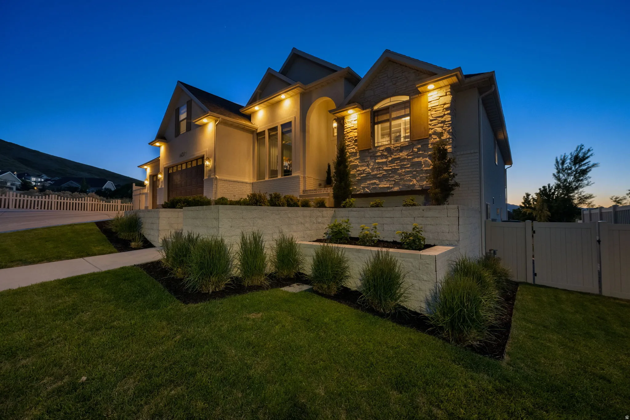 Contemporary exterior featuring stone accents, stucco siding, and a wood-finish garage door