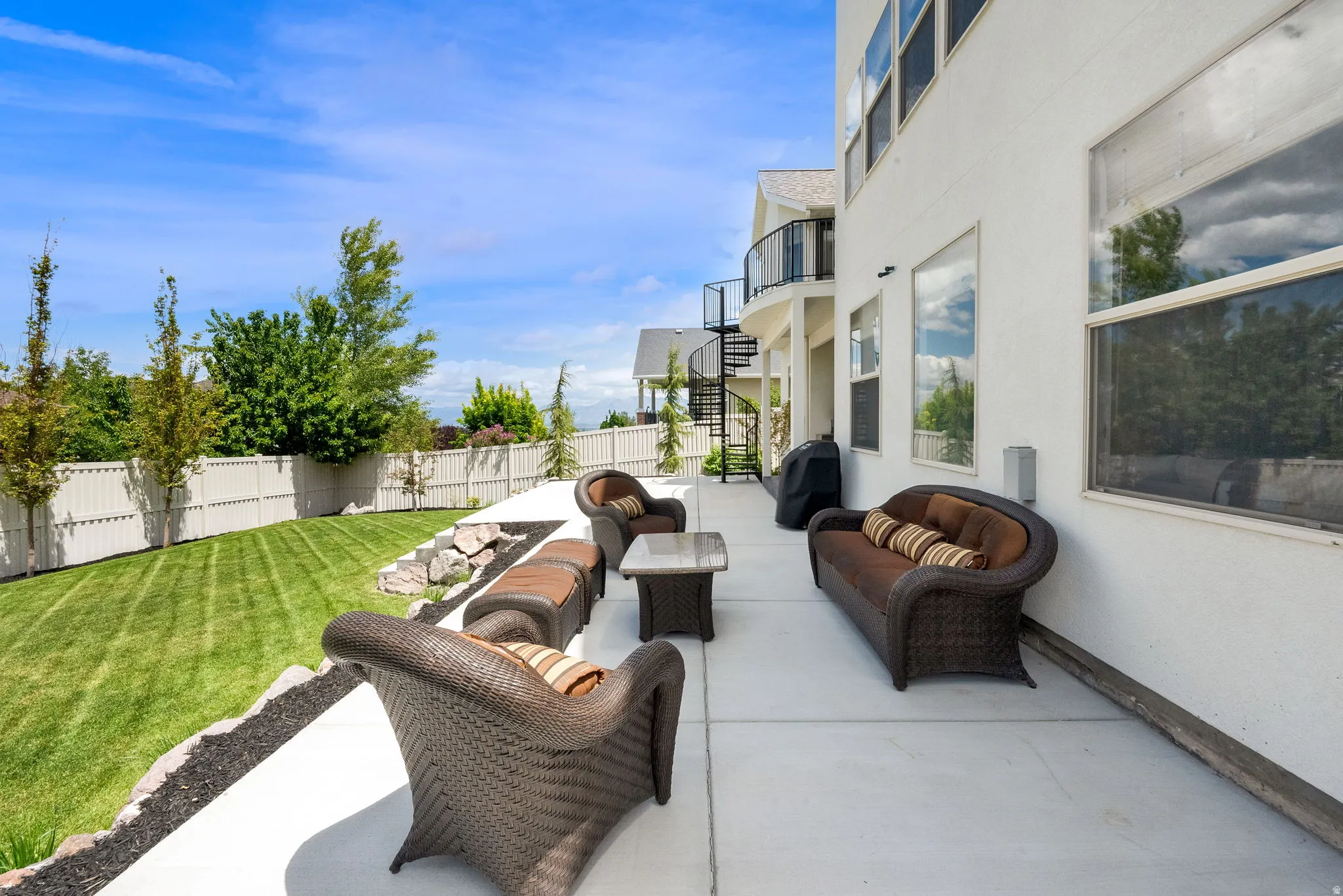 Expansive concrete patio with direct access to a manicured lawn