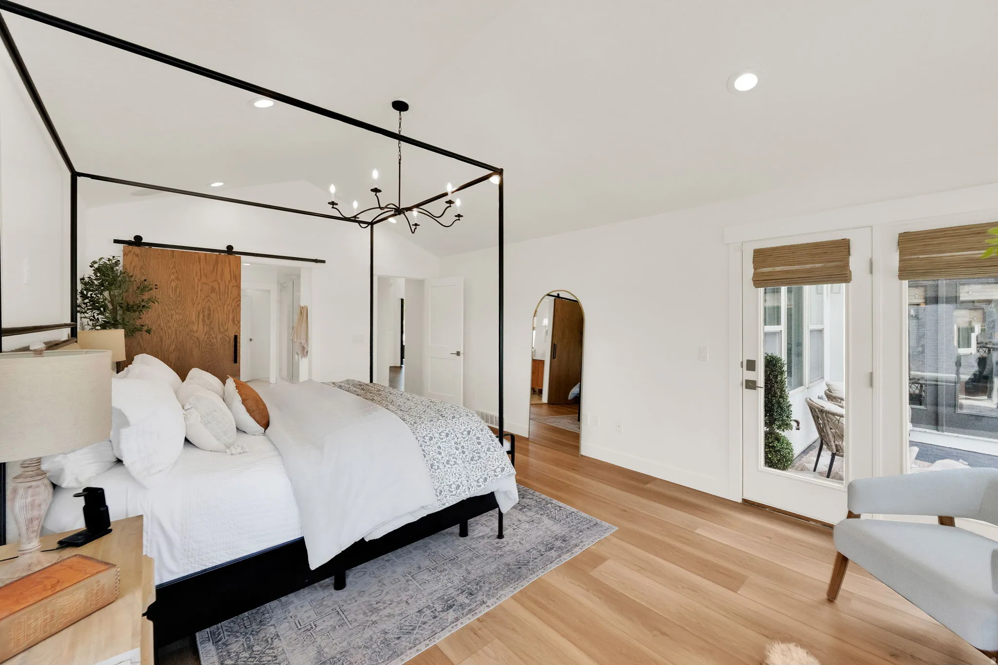 Recessed lighting illuminates wood-finish flooring and a vaulted ceiling