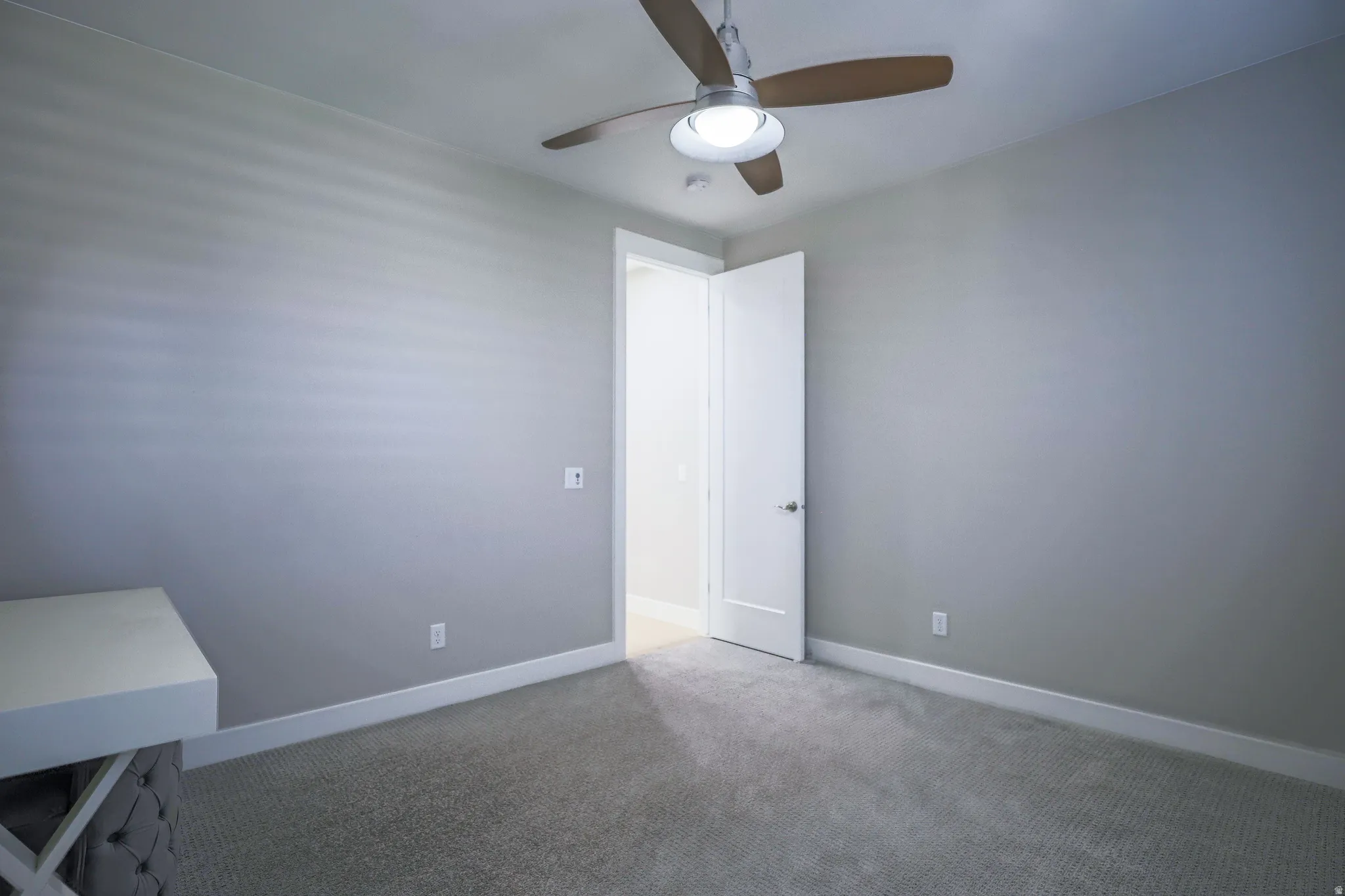 Room featuring a ceiling fan with integrated lighting, neutral wall paint, white baseboards, and light-colored carpeting