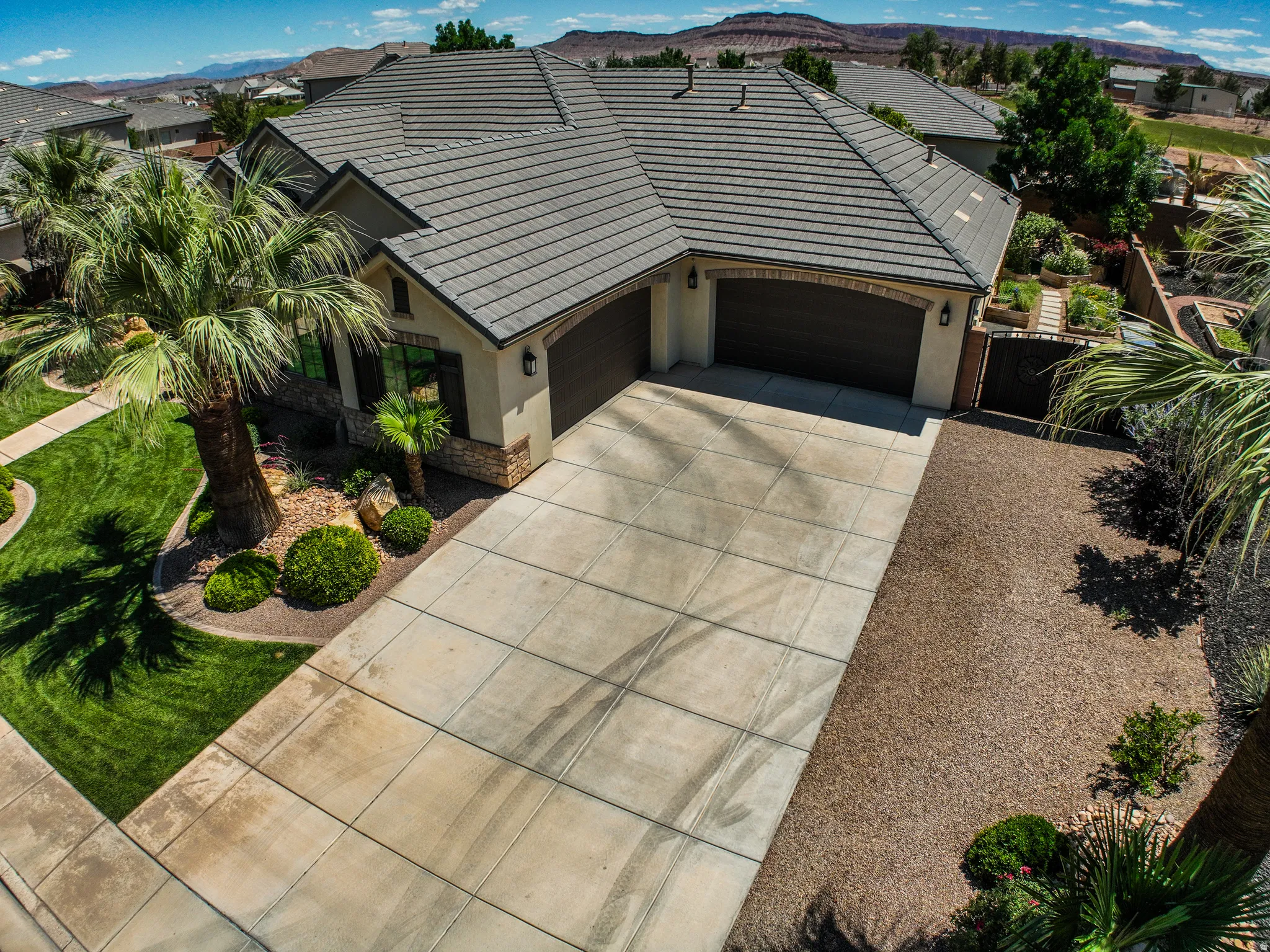 Exterior residence featuring a concrete tile roof, stucco and stone facade, and a two-car garage
