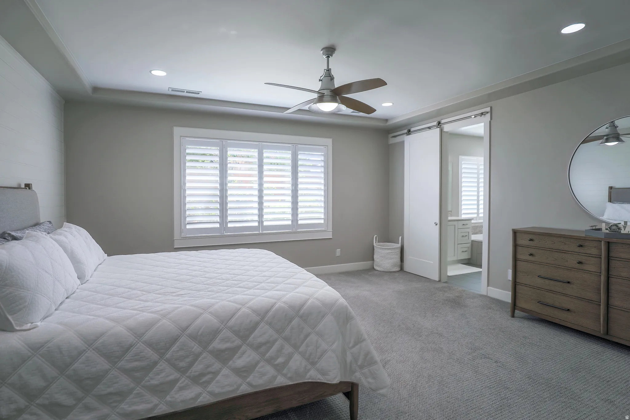 Spacious room featuring ceiling fan with integrated lighting, recessed lighting, and a tray ceiling