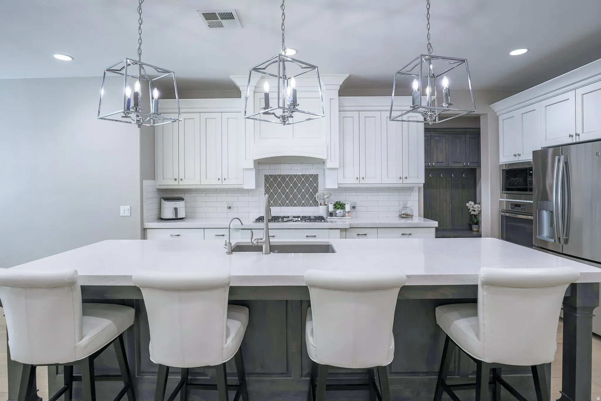 Spacious kitchen island with a light-toned countertop, sink, and integrated seating