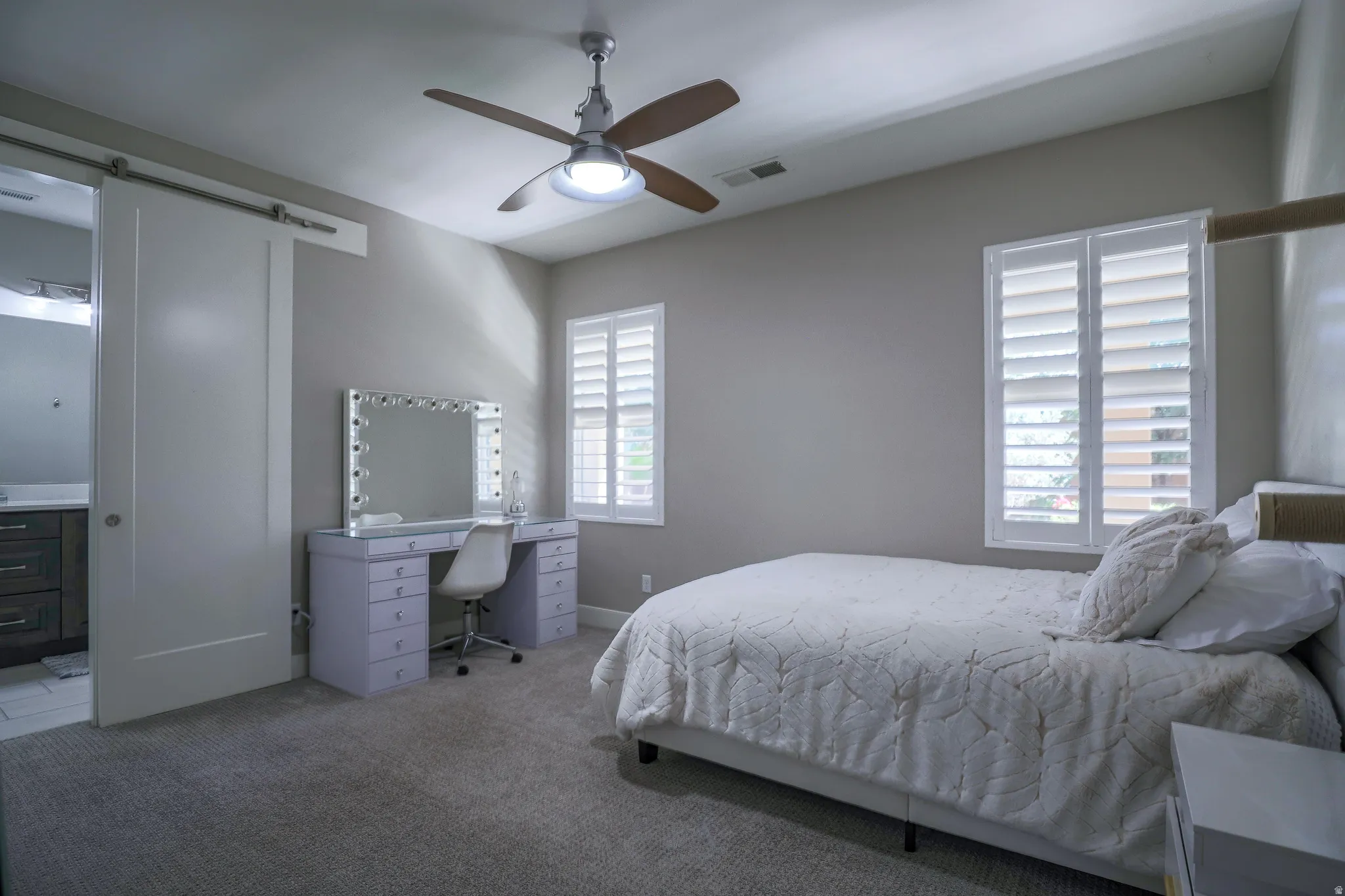 Spacious room featuring neutral-toned walls, plush carpeting, and a ceiling fan with integrated lighting