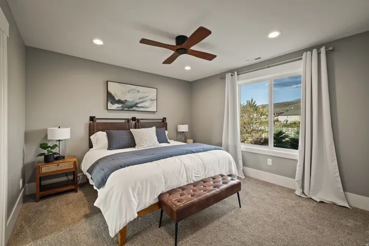 Carpeted room featuring a ceiling fan with integrated lighting, recessed lighting, and a large window