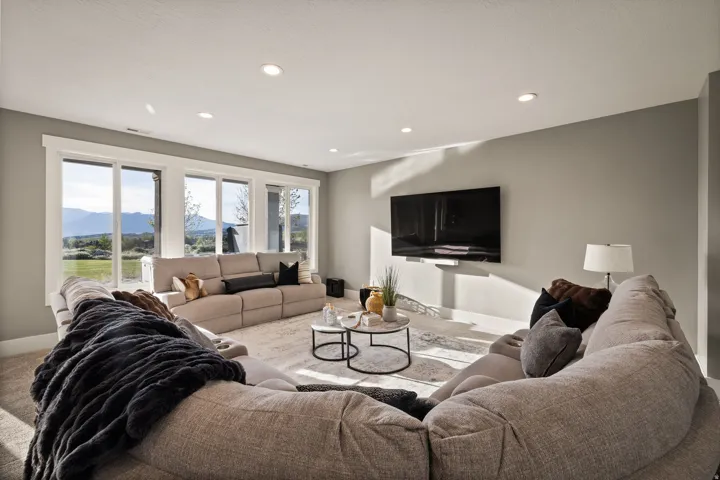 Spacious entertainment room featuring recessed lighting, light gray wall paint, and plush carpet flooring