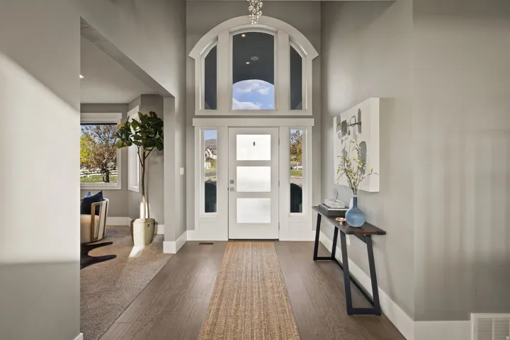 Grand entryway featuring a high ceiling, arched transom windows, and wood-finish flooring