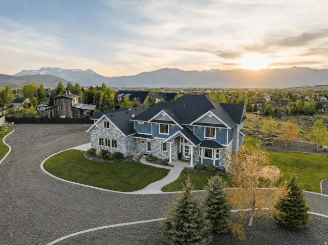 Contemporary residence featuring a multi-gabled roofline and a stone and siding exterior