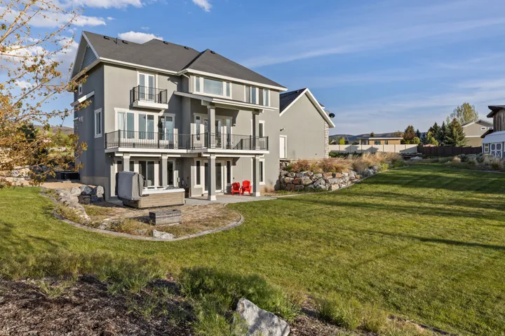 Multi-level exterior featuring light gray stucco siding and black framed windows