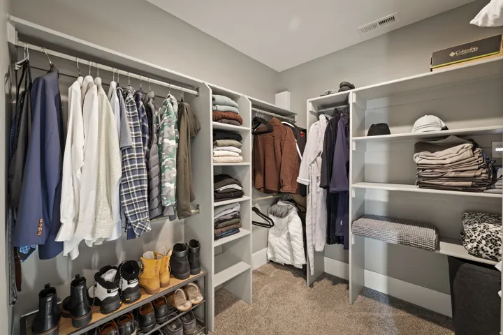 Custom closet system featuring multiple hanging rods, integrated shelving, and shoe storage