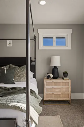 Recessed ceiling lighting, a window with white trim, and textured gray carpeting