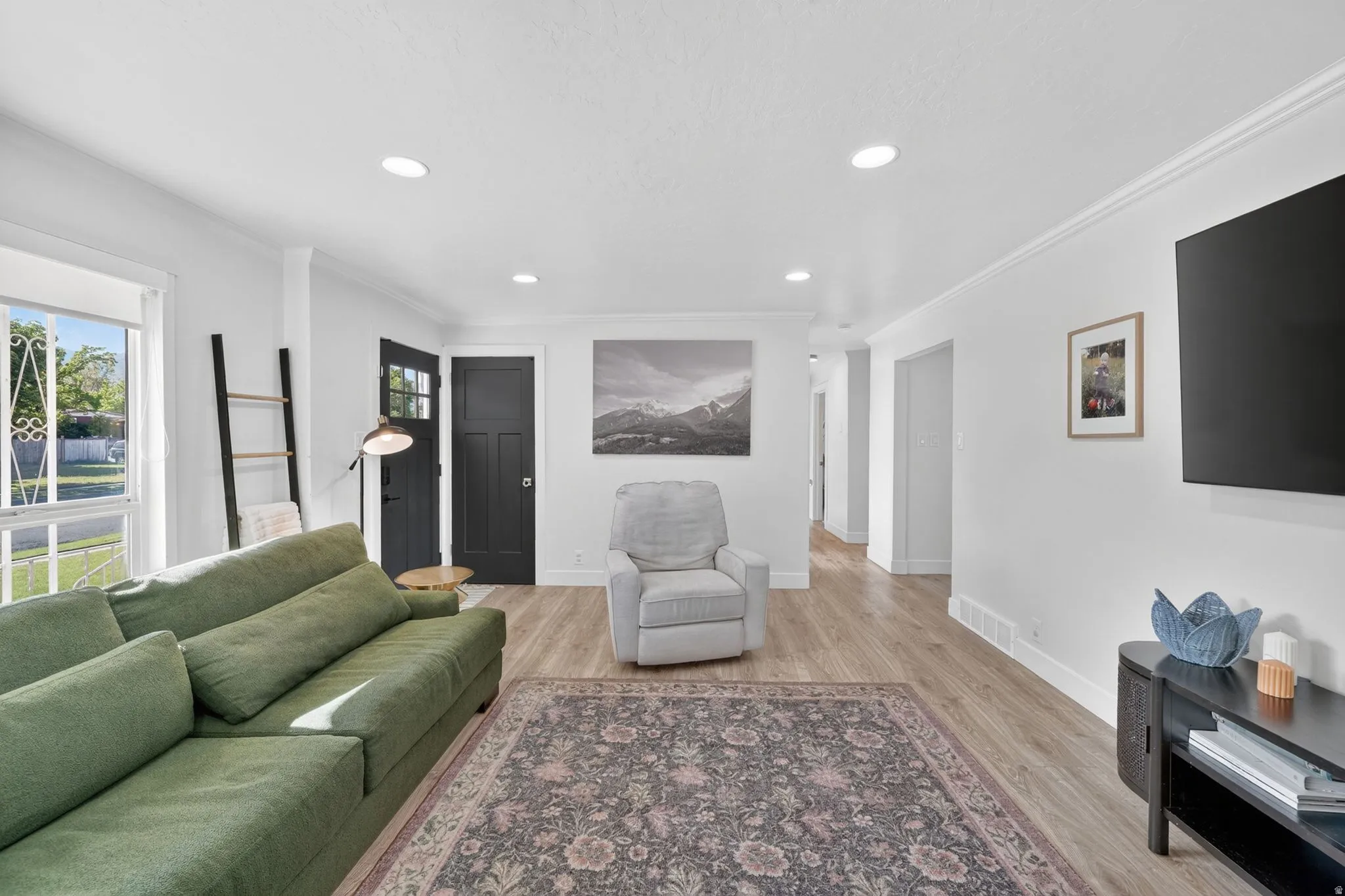 Open-concept living space featuring wood-finish flooring, recessed lighting, and white baseboards