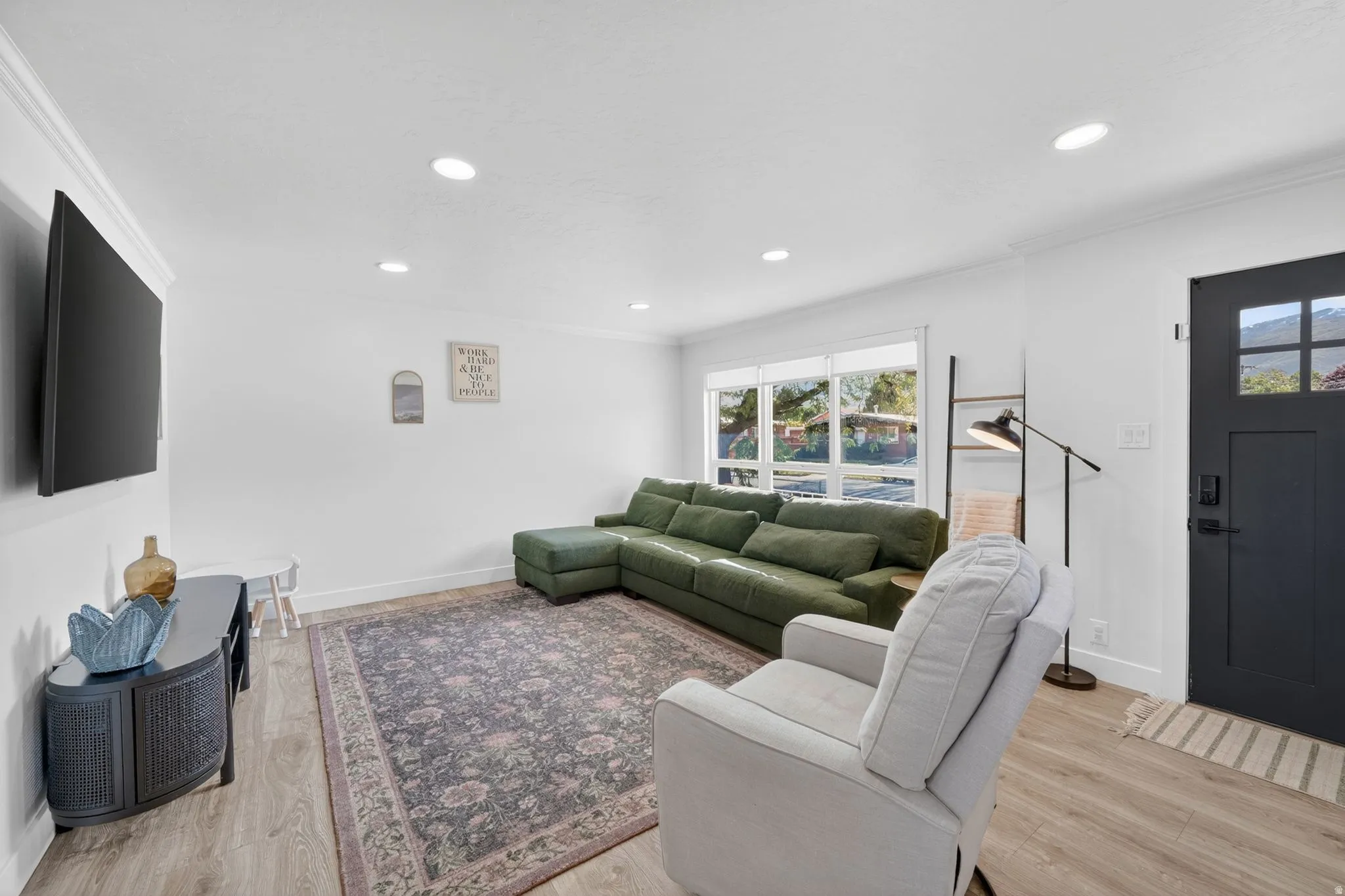 Bright living area featuring recessed lighting and crown molding