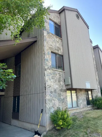 Multi-level structure featuring a stone and vertical siding exterior