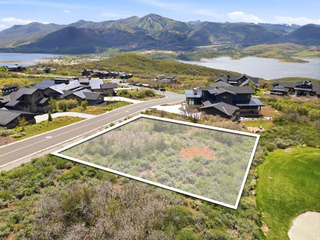 Expansive lot featuring natural vegetation, bordered by a paved road and golf course