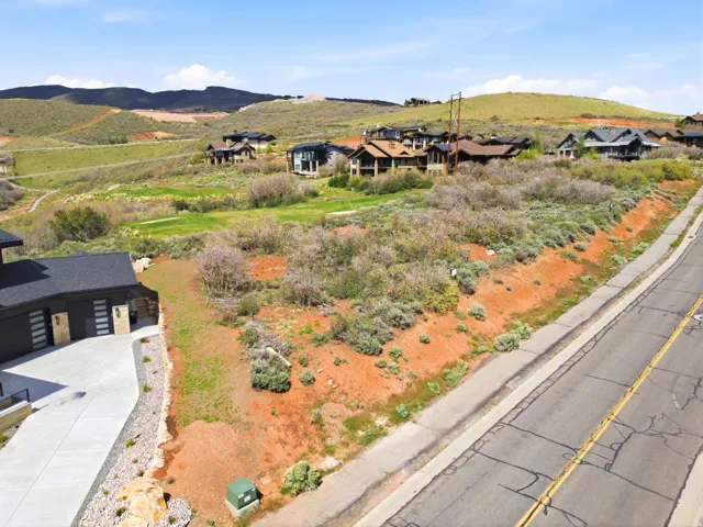 Elevated lot featuring natural desert landscaping and a paved roadway border