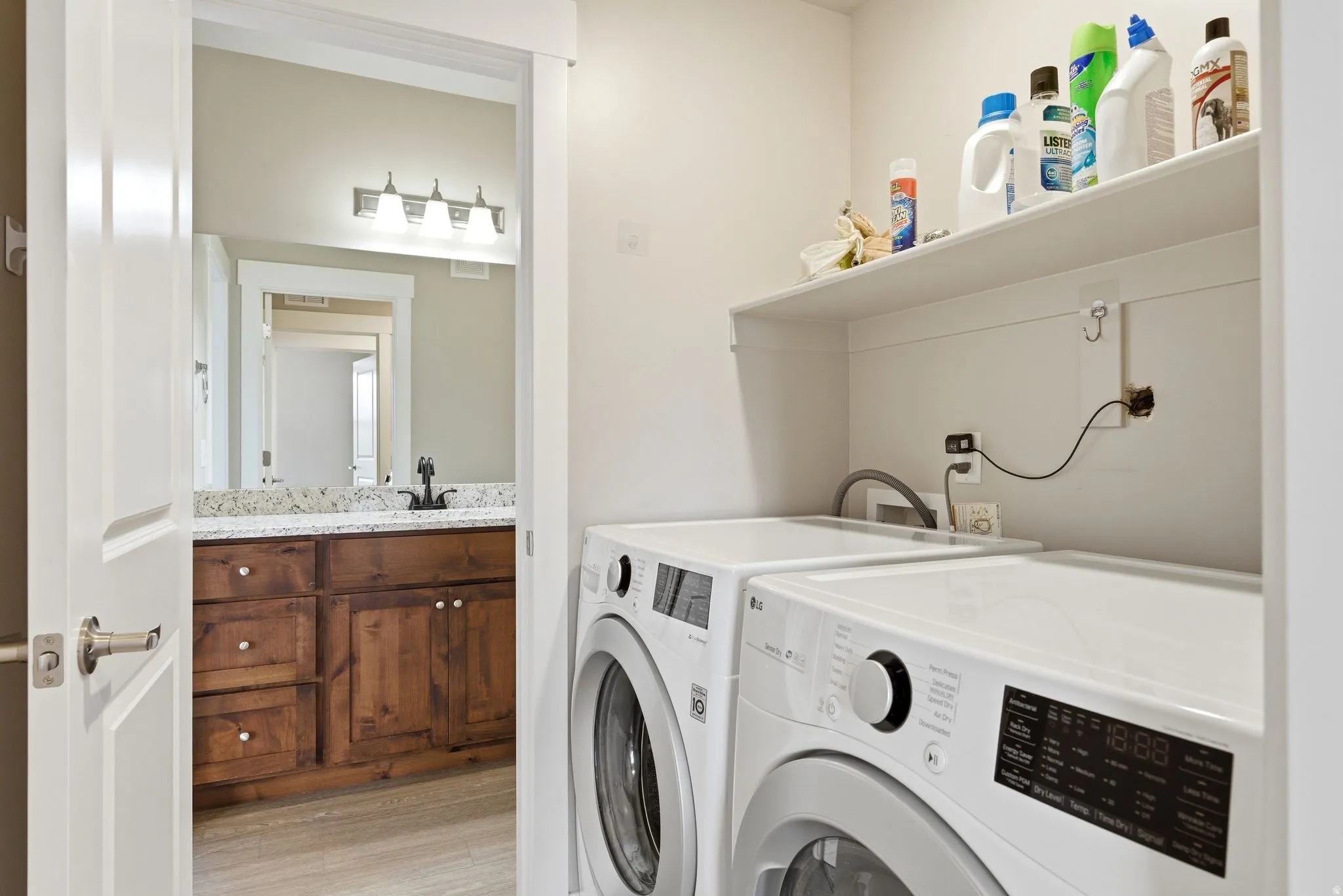 Dedicated laundry area featuring a built-in shelf and connections for appliances