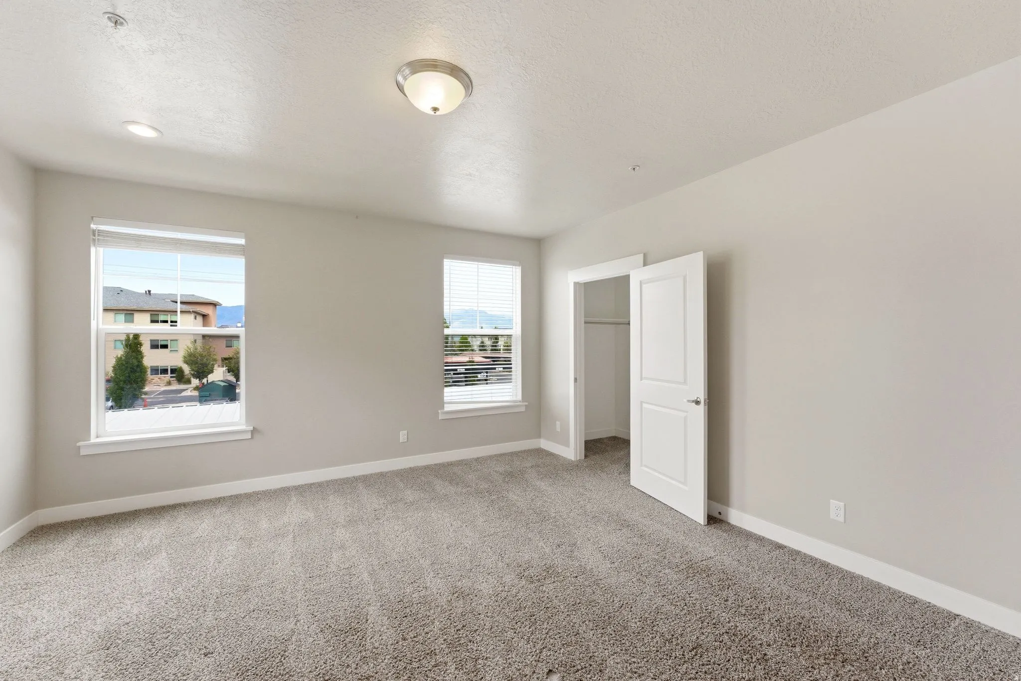 Spacious room featuring neutral carpeting and light-toned walls