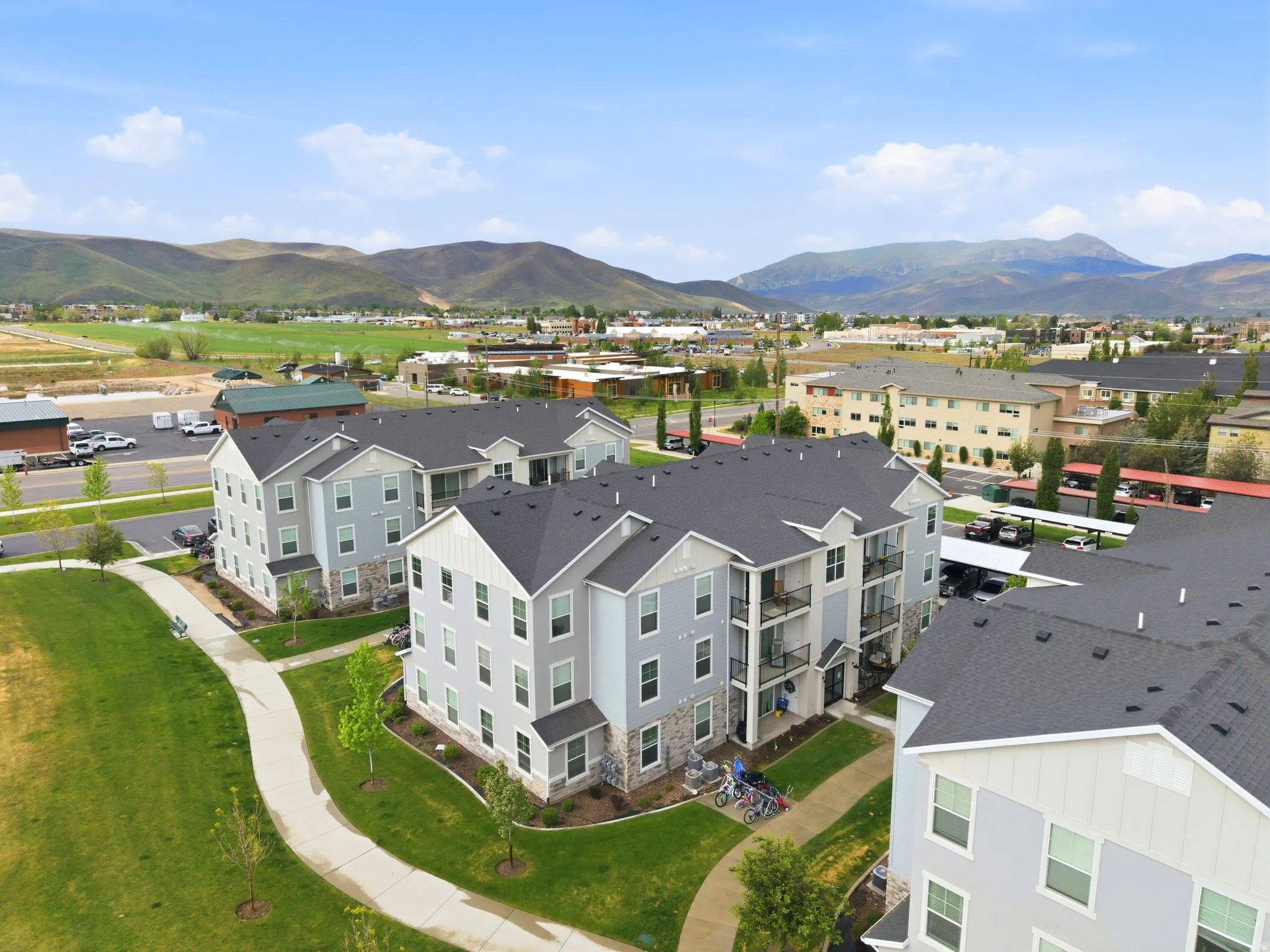 Modern multi-story buildings featuring light-toned siding and stone veneer accents