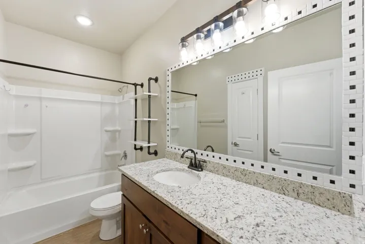 Bathroom featuring a single vanity with a light-colored countertop and a dark wood-finish cabinet