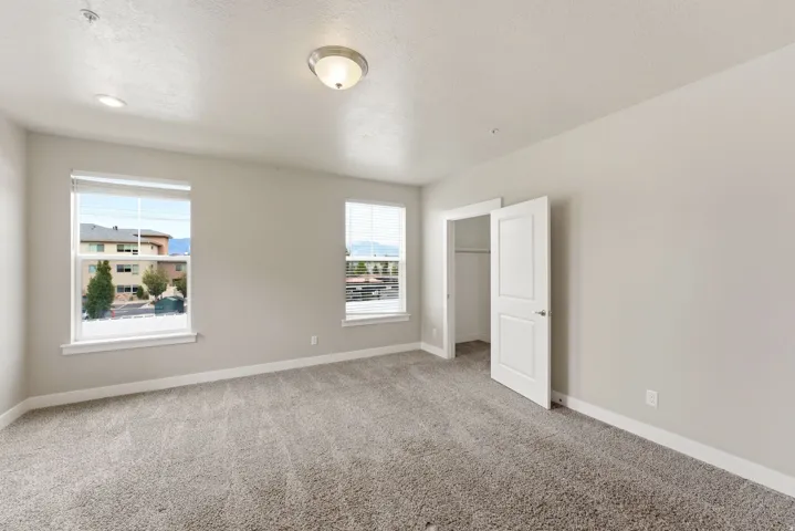 Spacious room featuring neutral carpeting and light-toned walls