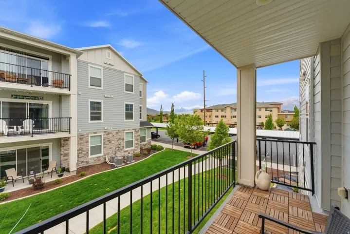 Private balcony with wood-finish tile flooring and black metal railings