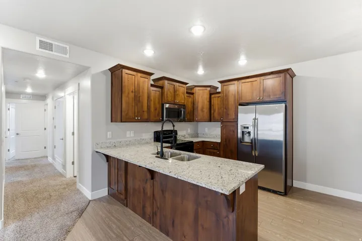 Modern kitchen featuring rich wood cabinetry, granite countertops, and stainless steel appliances