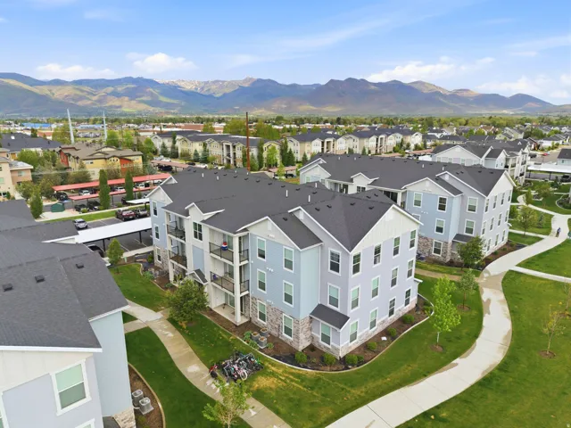 Contemporary multi-story buildings featuring light blue siding, white trim, and stone veneer accents
