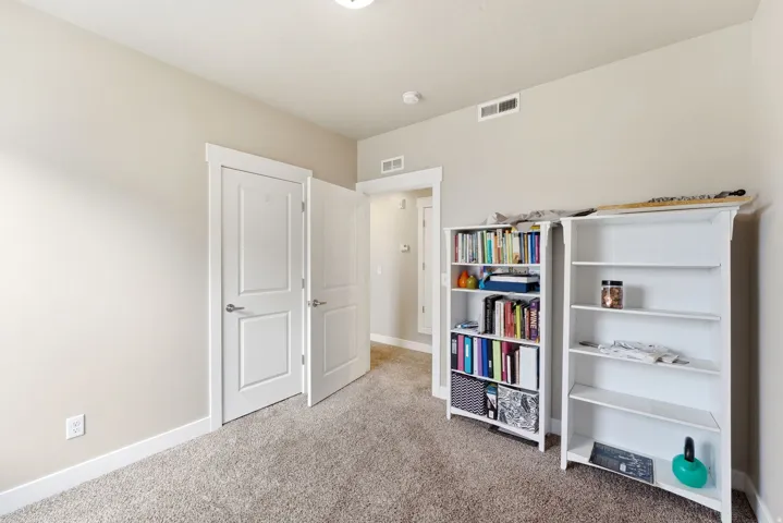 Neutral-toned room with light beige wall paint, white baseboards, and light brown carpet flooring