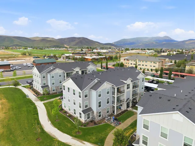 Modern multi-story buildings featuring light-toned siding and stone veneer accents