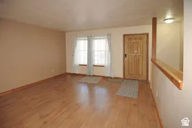Entryway featuring wood-finish flooring, a solid wood entry door, and a half-wall partition
