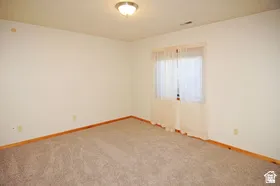 Neutral-toned carpet flooring with light wall paint and natural wood baseboards